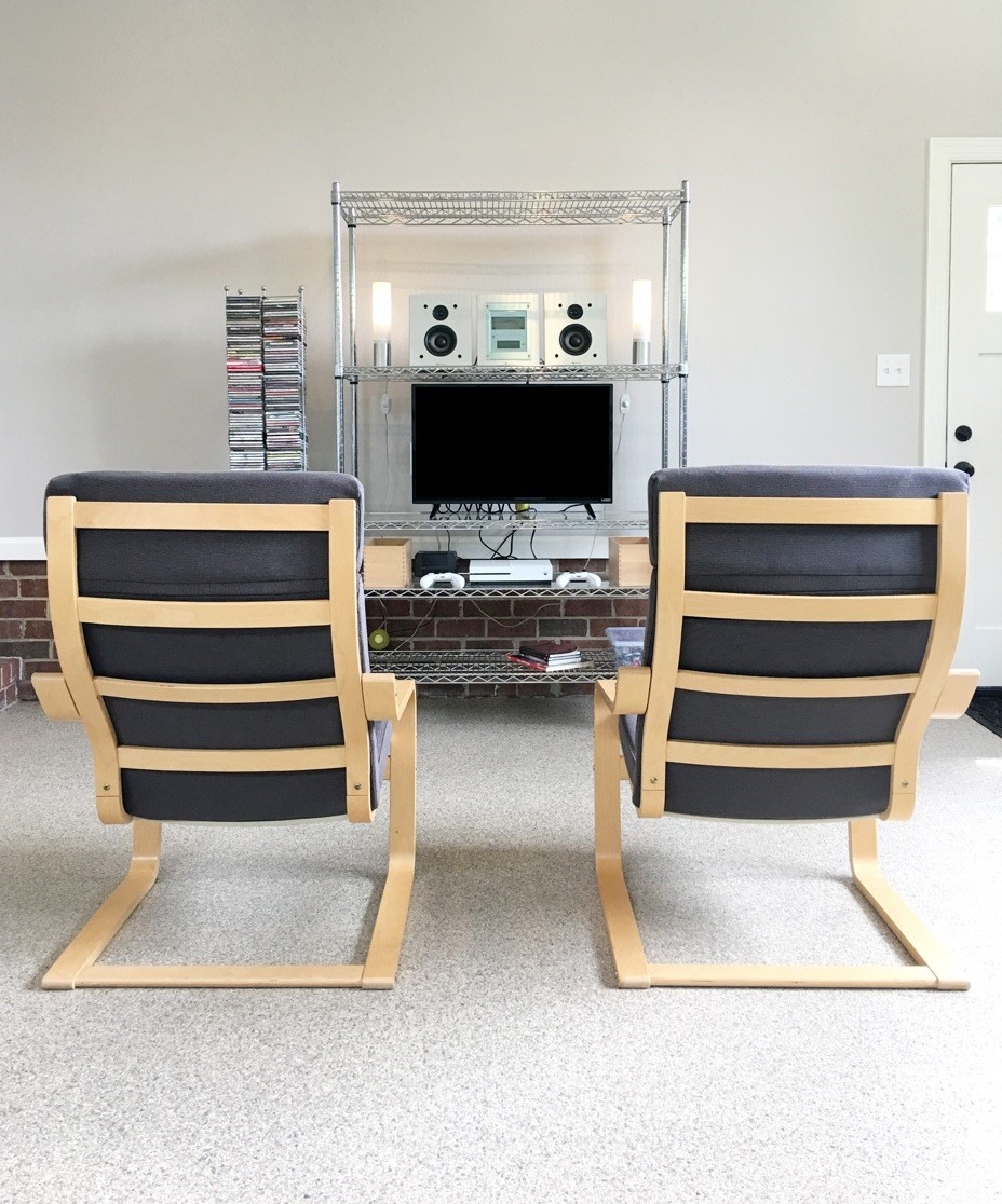 two chairs and a chrome wire shelving unit set up as an entertainment center 