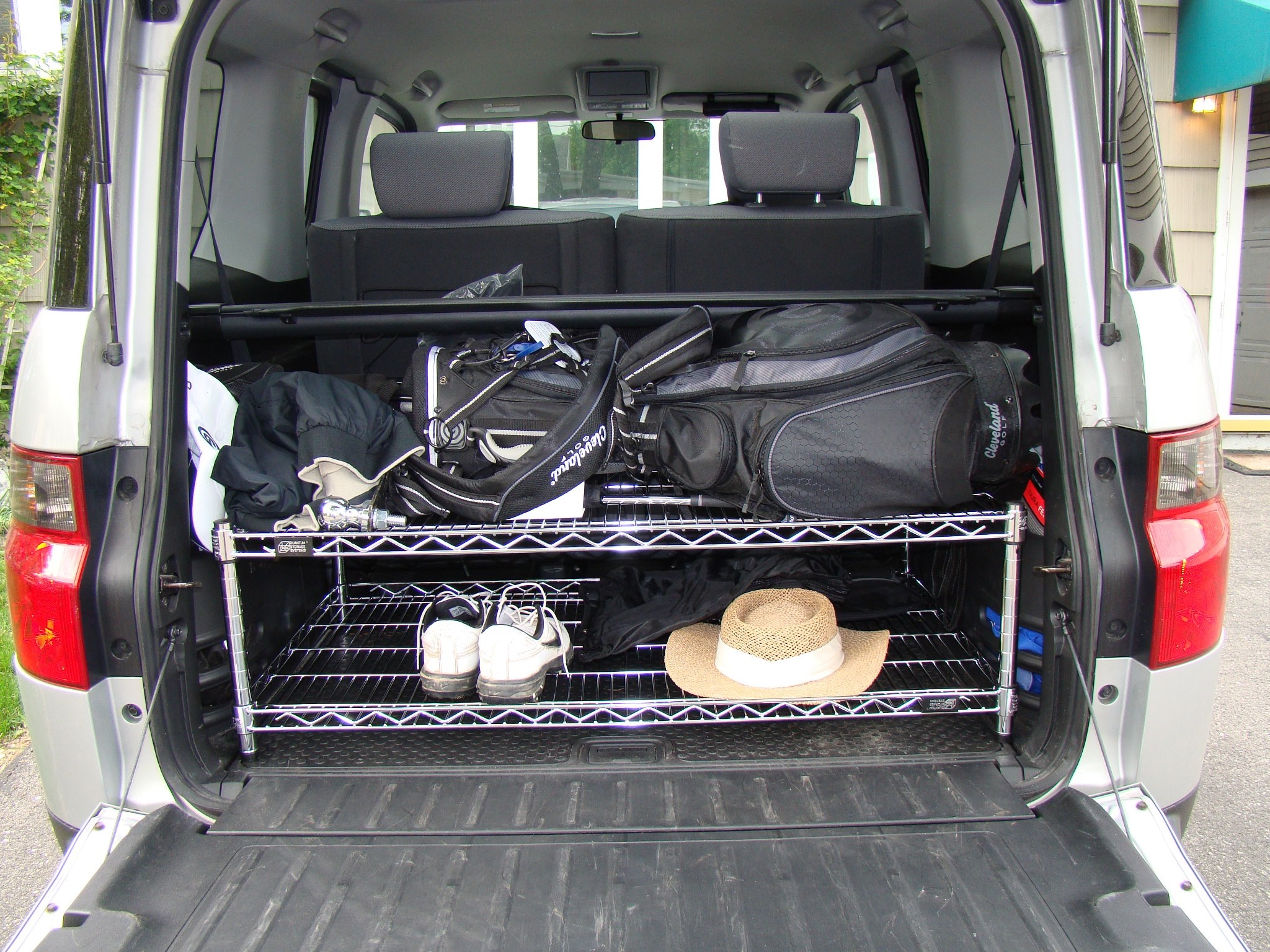 open car trunk with wire shelving to help transport sporting equipment and luggage