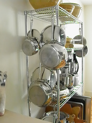 chrome wire shelf displaying hanging pots and pans