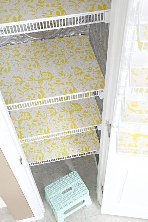 white wire shelves in closet with yellow and white floral pattern shelf liners